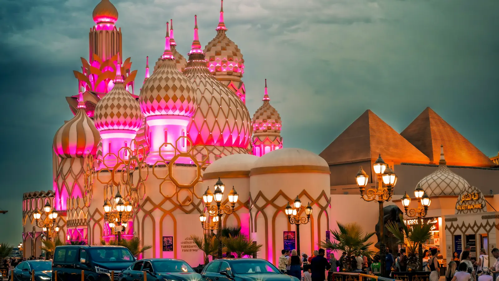 Ornate pavilion domes lit in pink at dusk at Global Village Dubai
